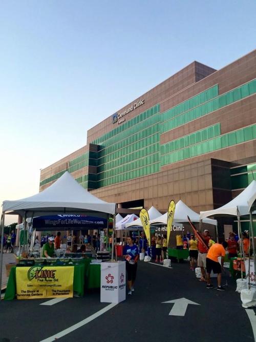 Tents and booths set up for an event outside the Cleveland Clinic building, with people participating in activities.