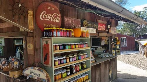 A rustic shop exterior with shelves of colorful jars, a Coca-Cola sign, and a welcoming atmosphere.