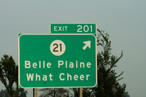 Green highway sign indicating exit 201 for Belle Plaine and What Cheer, with route number 21.
