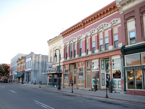 Historic buildings line a quiet street, showcasing colorful facades and unique architectural details.