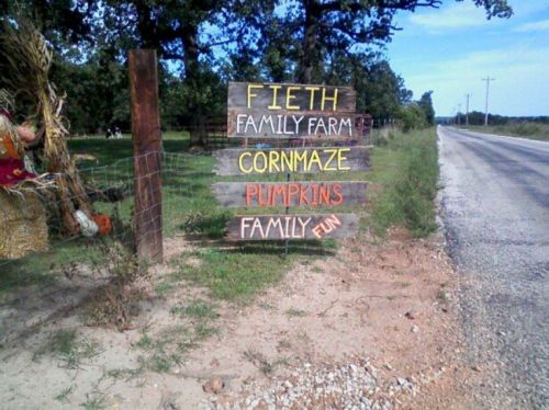 Sign for Fieth Family Farm featuring a corn maze and pumpkins, promoting family fun along a rural road.