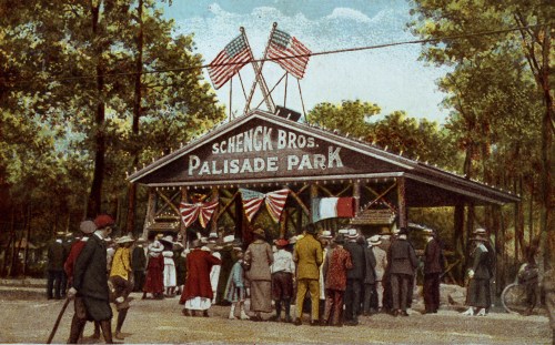 Historic entrance to Schenck Bros. Palisade Park, featuring flags and a crowd of people in early 20th-century attire.