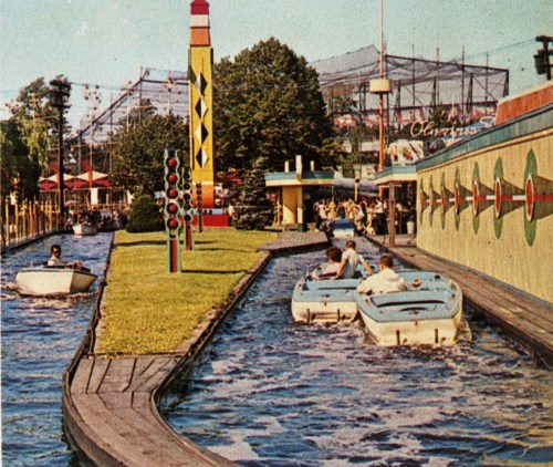 A vintage amusement park scene with colorful boats on a winding waterway, surrounded by greenery and attractions.