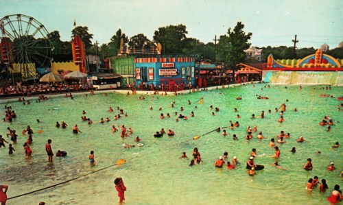 A vibrant water park scene with people swimming, colorful attractions, and a ferris wheel in the background.