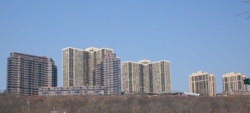 A skyline view of several tall residential buildings against a clear blue sky.