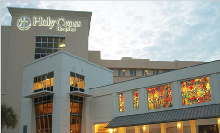 Exterior view of Holy Cross Hospital, featuring a modern building and colorful stained glass windows.