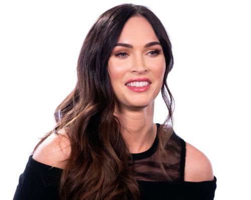 A woman with long dark hair smiles, wearing a black off-shoulder top against a bright background.