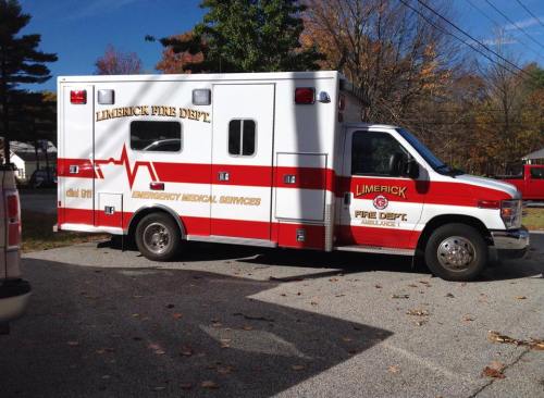 A Limerick Fire Department ambulance parked on a gravel surface, featuring red and white markings.