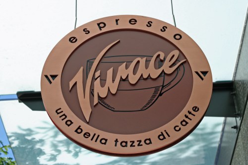 Sign for "Vivace" espresso featuring a coffee cup graphic and the phrase "una bella tazza di caffè."