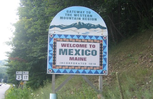 Sign welcoming visitors to Mexico, Maine, with a decorative border and mountain imagery, indicating it's part of the Western Mountain Region.