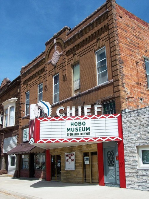 Historic building with a marquee reading "Hobo Museum" and a decorative facade, set against a clear blue sky.