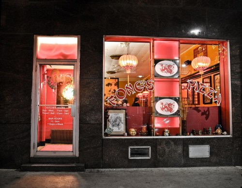 A brightly lit pizza restaurant with red decor and lanterns, featuring large windows displaying the name "Fong's Pizza."