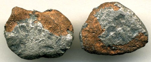Two irregularly shaped metallic rocks with a mix of shiny silver and rusty brown surfaces.