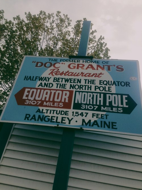 Sign for "Doc Grant's Restaurant" in Rangeley, Maine, noting its distance from the Equator and North Pole.