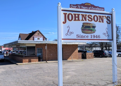 A restaurant building with a sign reading "Johnson's" and "Over 70 Years of Excellence" in a sunny outdoor setting.