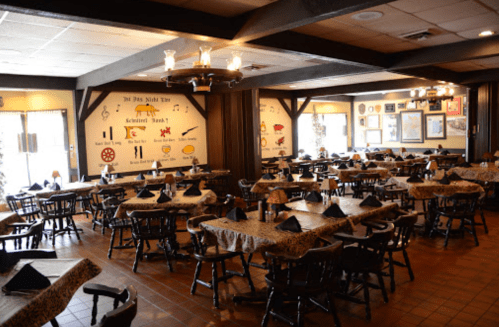 A spacious restaurant interior with wooden tables, chairs, and themed wall decor, featuring a cozy, inviting atmosphere.