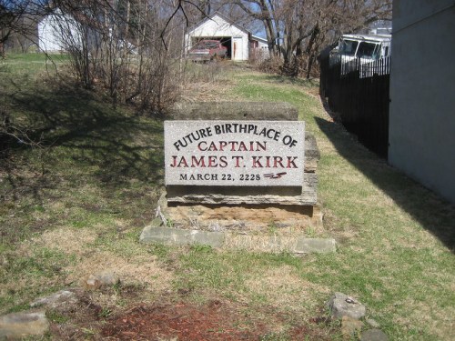 Sign marking the future birthplace of Captain James T. Kirk, dated March 22, 2228, in a grassy area.