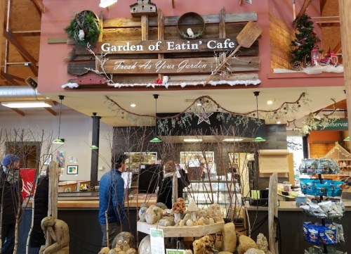 Interior of the Garden of Eatin' Café, featuring rustic decor, a display of food items, and patrons at the counter.