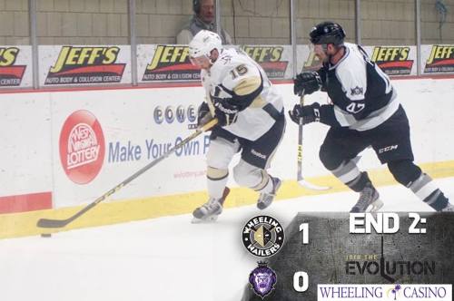 A hockey game in progress with Wheeling Nailers player skating with the puck, leading 1-0 at the end of the second period.