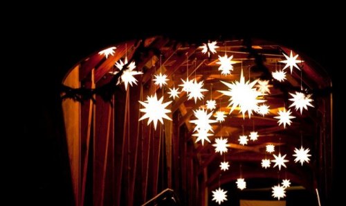 A dimly lit wooden archway adorned with glowing star-shaped lights hanging from the ceiling.