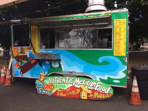 Colorful food truck with a sign reading "Authentic Mexican Food" and a menu featuring tacos, open Monday to Saturday.