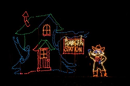 Colorful holiday lights depict a house and a cowboy figure holding a sign that reads "Rancher Station."
