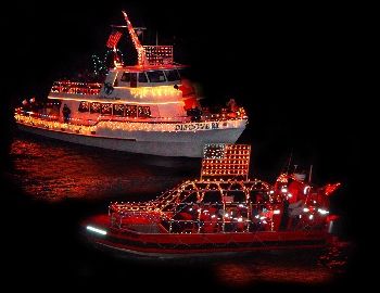 Two brightly lit boats decorated with festive lights, floating on dark water at night.