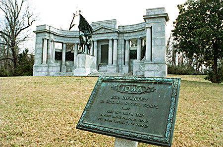 Monument honoring the 26th Iowa Infantry, featuring a statue and plaque, set in a grassy area with trees.