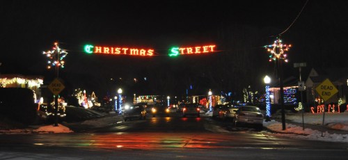 A festive street at night, adorned with colorful Christmas lights and a sign reading "Christmas Street."