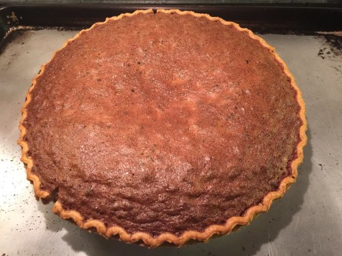A freshly baked pie with a golden-brown crust, sitting on a baking sheet.