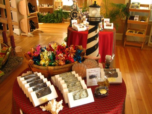 A cozy shop display featuring colorful wrapped candies, decorative items, and a lighthouse figurine on a table.