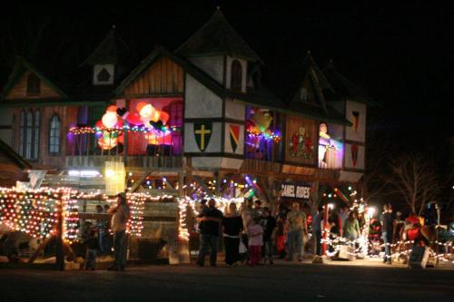 A festive building adorned with colorful lights and decorations, with people gathered outside at night.