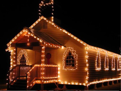 A warmly lit building decorated with string lights, showcasing a cozy, festive atmosphere at night.