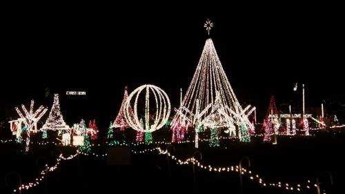 A festive display of colorful Christmas lights, featuring trees, ornaments, and a large illuminated star.