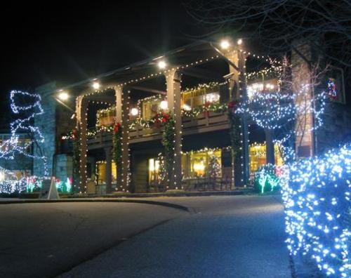 A beautifully decorated building at night, adorned with colorful holiday lights and festive greenery.