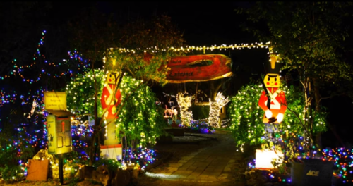 A festive pathway adorned with colorful lights and nutcracker decorations, leading to a cheerful holiday display.