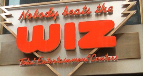 Sign for "The Wiz" Total Entertainment Centers with the slogan "Nobody beats the WIZ" in bold red letters.