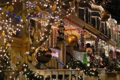 A festive street adorned with colorful Christmas lights and large ornaments, creating a cheerful holiday atmosphere.