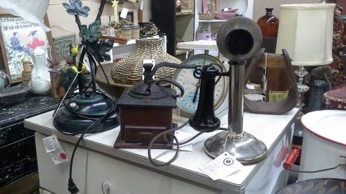A collection of vintage items including a lamp, an old-fashioned iron, and a phonograph on a table.