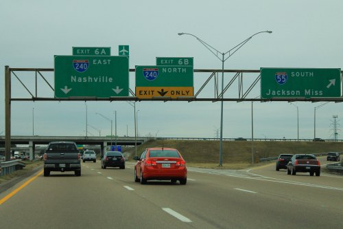 Highway scene with green exit signs for Nashville and Jackson, Mississippi, and vehicles traveling in multiple lanes.