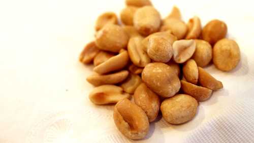 A pile of roasted peanuts on a white napkin.