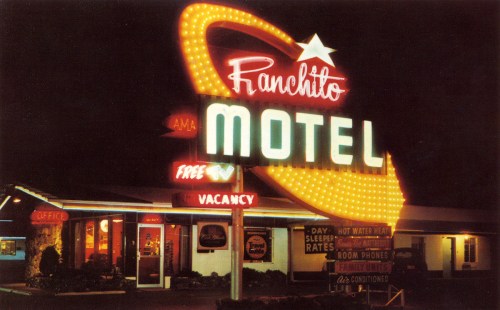 Neon sign of Ranchito Motel at night, featuring bright colors and a retro design, with "Vacancy" and "Free" displayed.