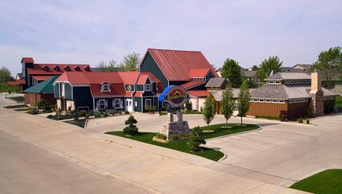 A colorful building complex with a large sign, surrounded by landscaped greenery and a clear blue sky.