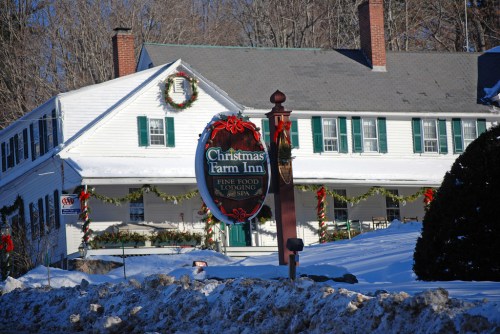 A snowy scene featuring the Christmas Farm Inn, decorated with wreaths and festive garlands.