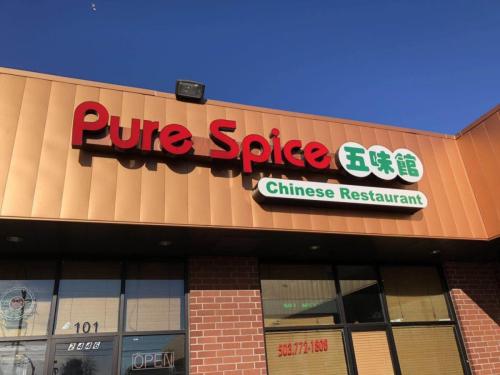 Sign for "Pure Spice" Chinese Restaurant with red and green lettering on a building exterior.