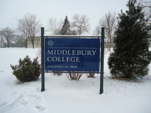 Sign for Middlebury College, founded in 1800, surrounded by snow and trees in a winter landscape.