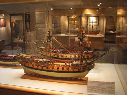 A detailed model of a historic ship displayed in a museum, showcasing intricate craftsmanship and rigging.