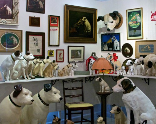 A collection of dog figurines and artwork displayed on walls and shelves in a cozy room.