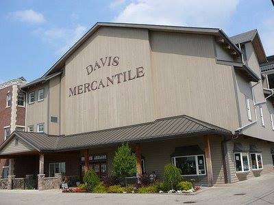Exterior view of Davis Mercantile, a large wooden building with a sloped roof and landscaped entrance.