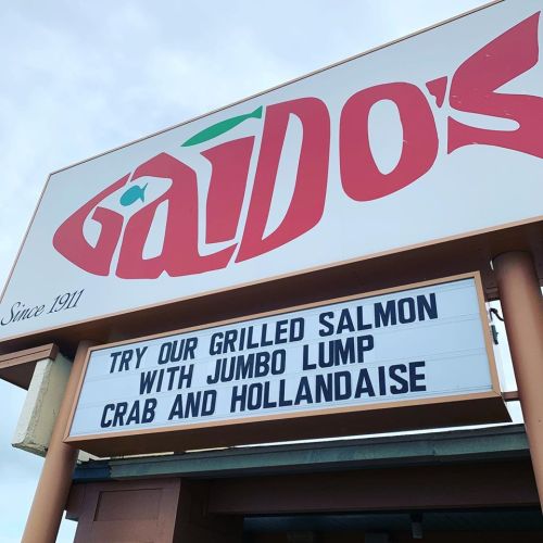 Sign for Gaido's restaurant promoting grilled salmon with jumbo lump crab and hollandaise.